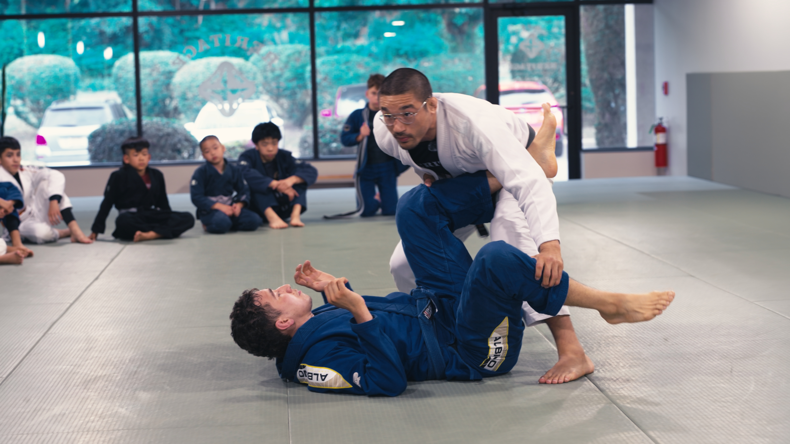 Brazilian jiu-jitsu professor demonstrating technique for students